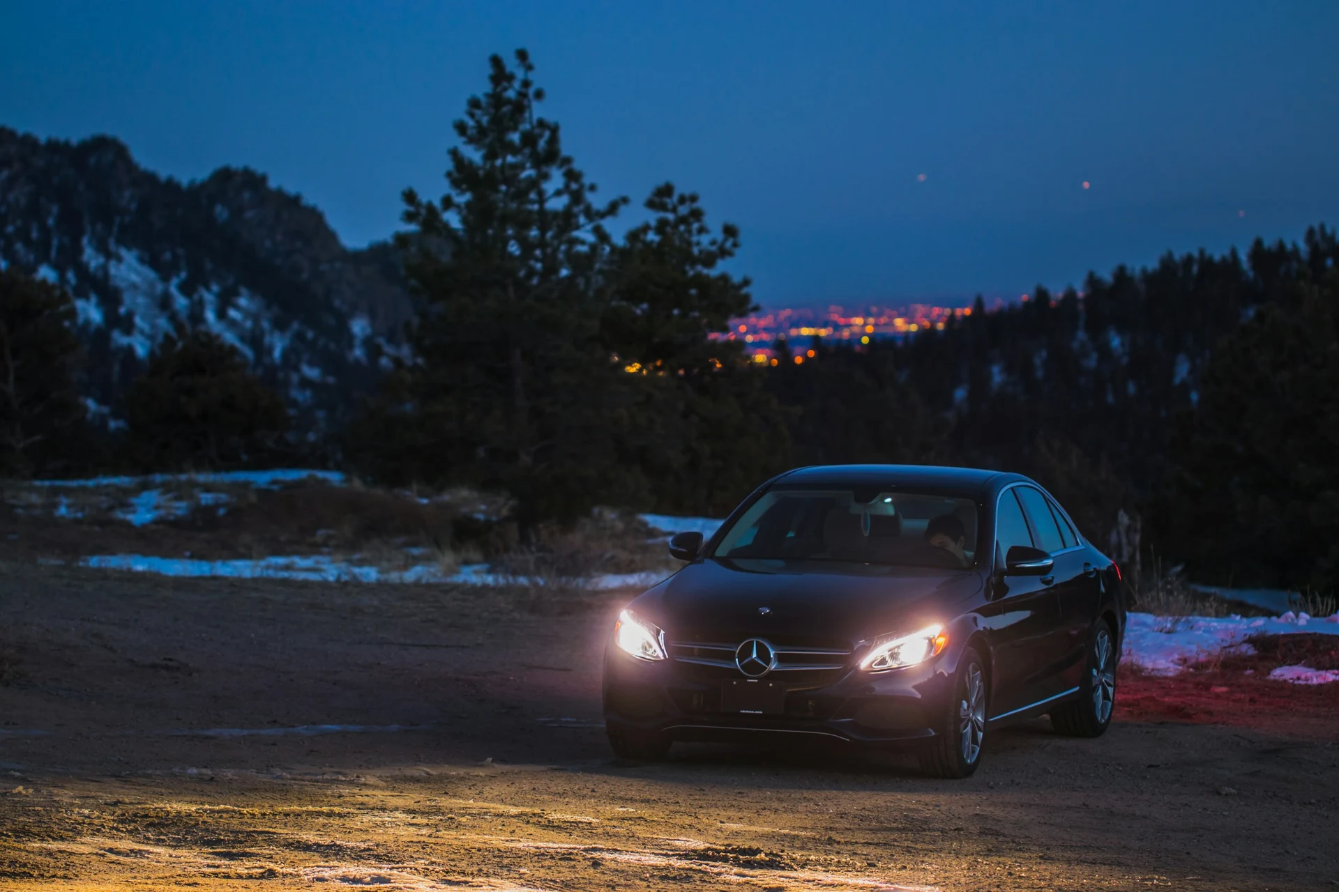 Berline Mercedes noire dans un paysage de montagne au crépuscule